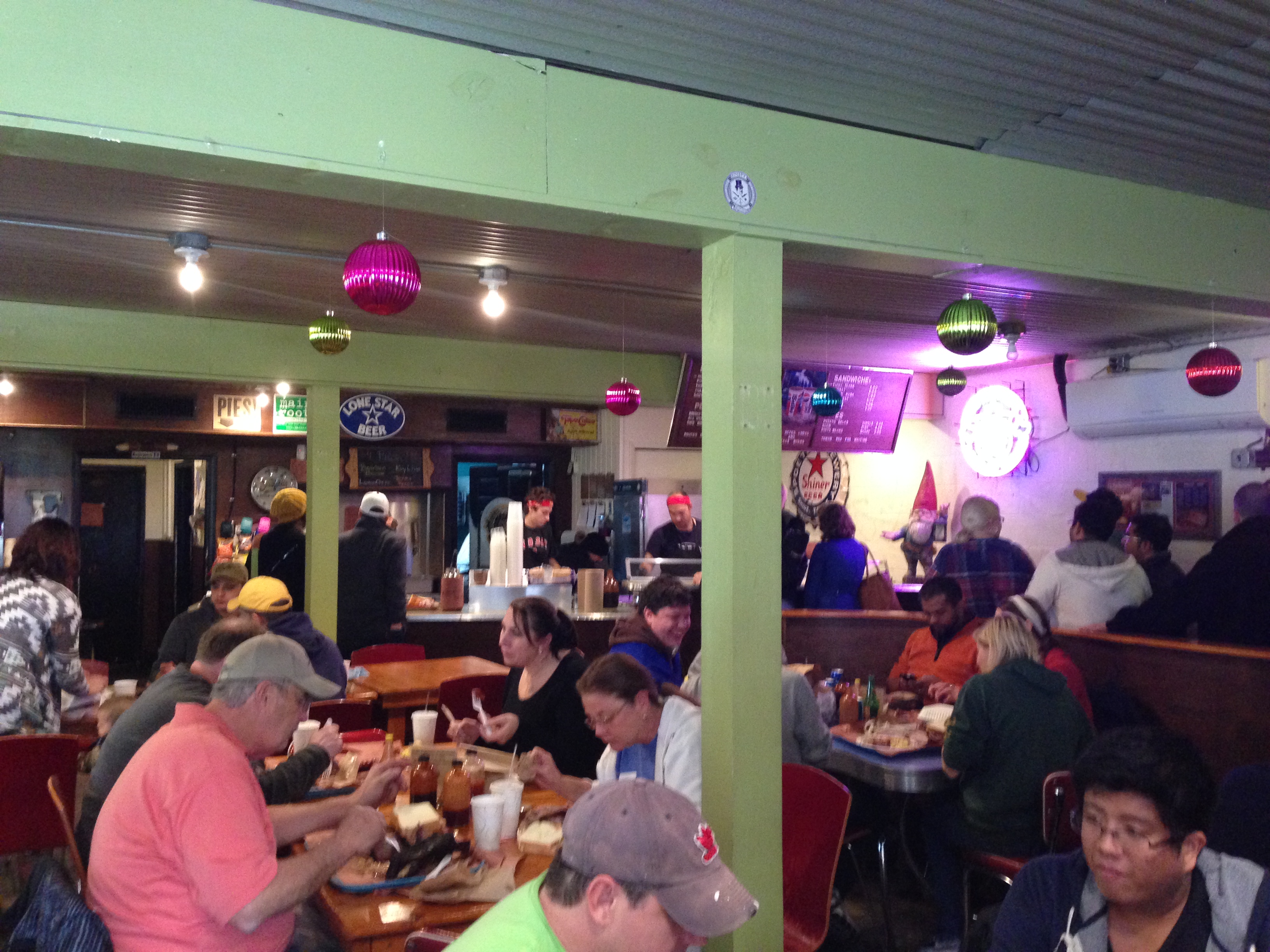 Inside Franklin — packed tables, pink butcher paper, cold beer, and happy people