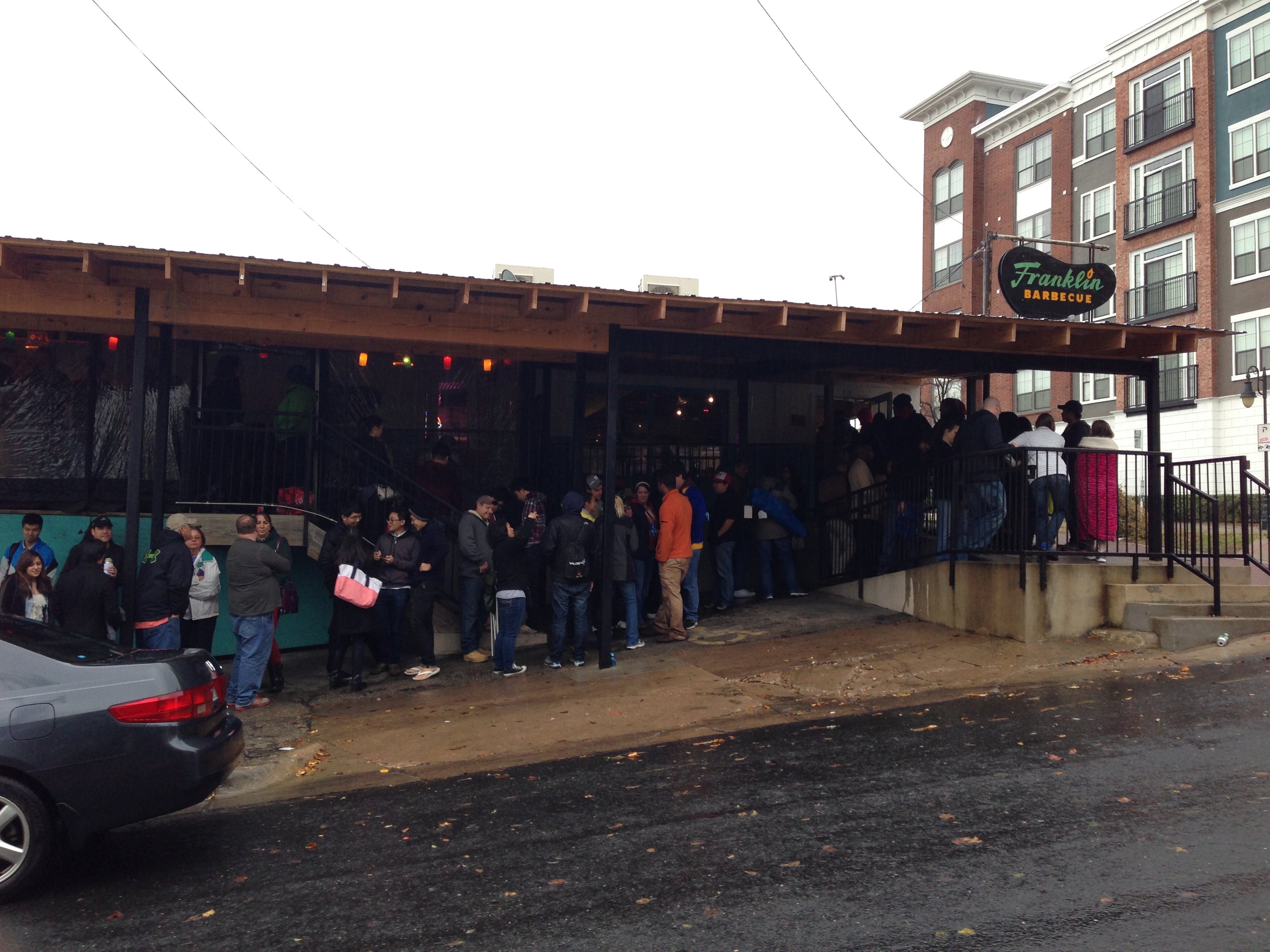 The line outside Franklin BBQ — dozens of people queuing under the covered patio