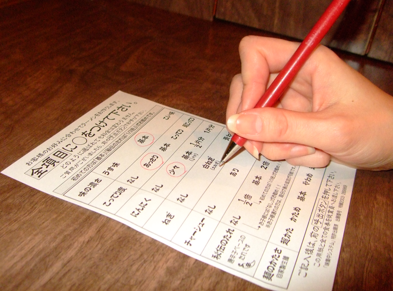 Hand filling out the Ichiran customization order form