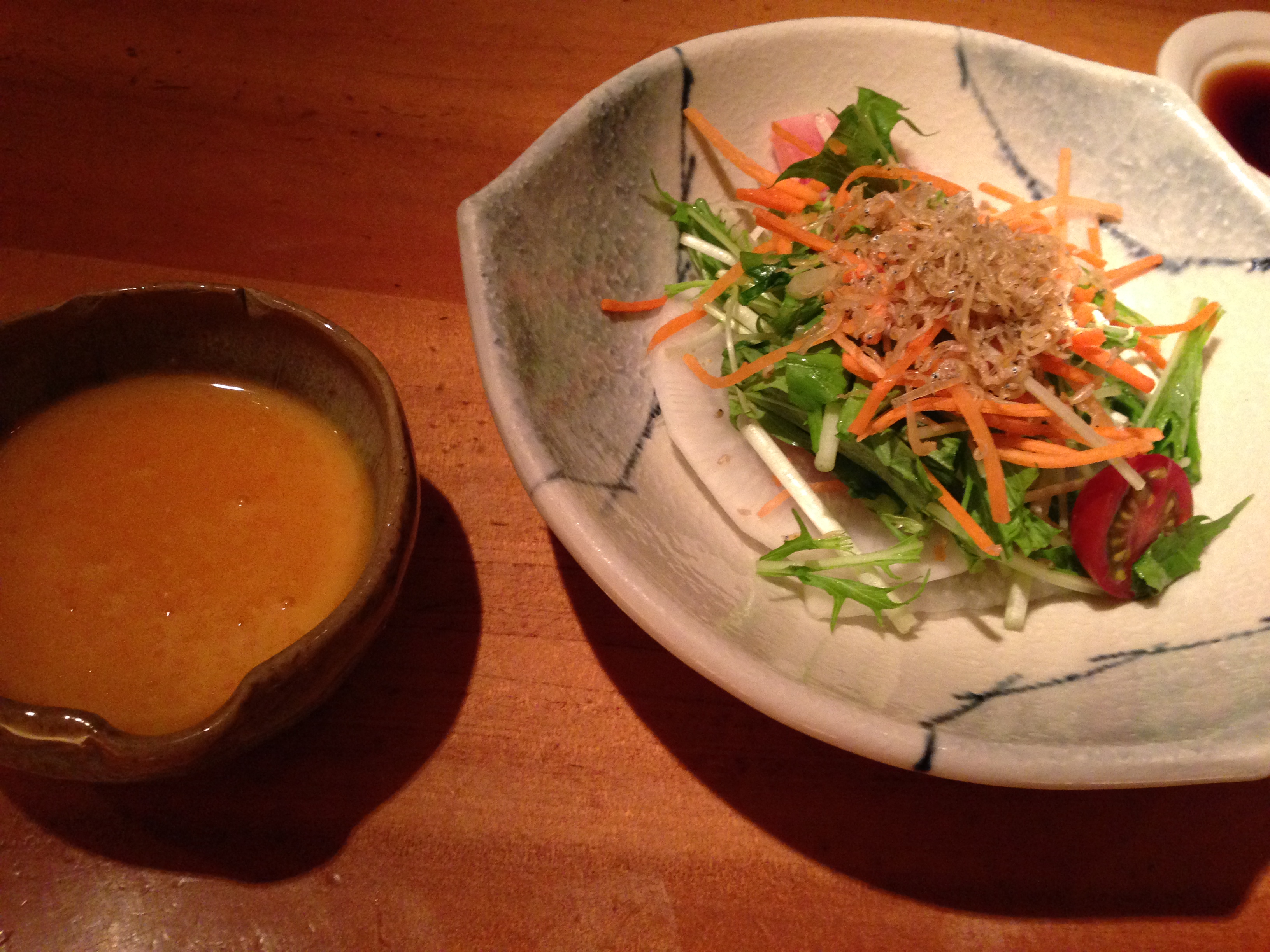 Salad of mizuna, carrot, and cherry tomato with a yuzu-style dressing on the side