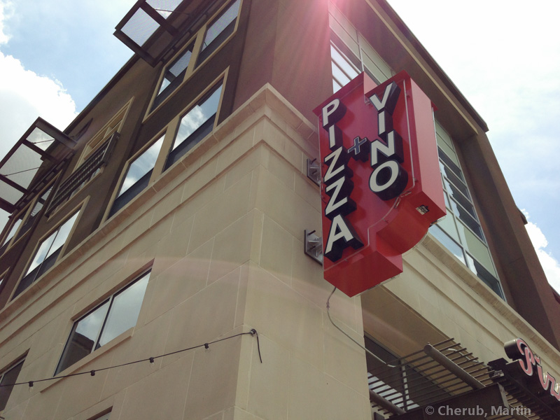 The Pizza + Vino neon sign from below