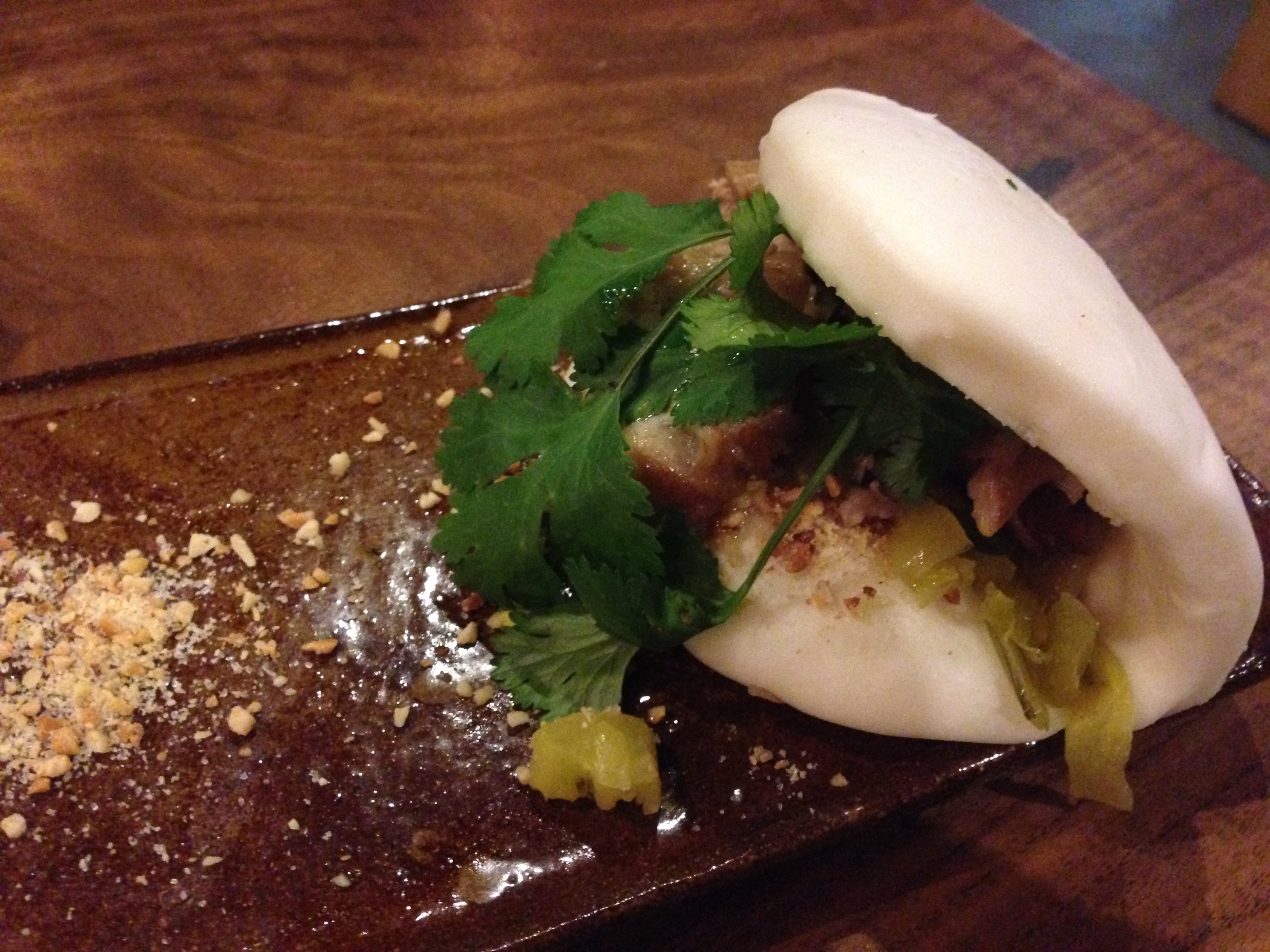 Gua bao — crispy pork belly in a steamed bun with cilantro and crushed peanuts