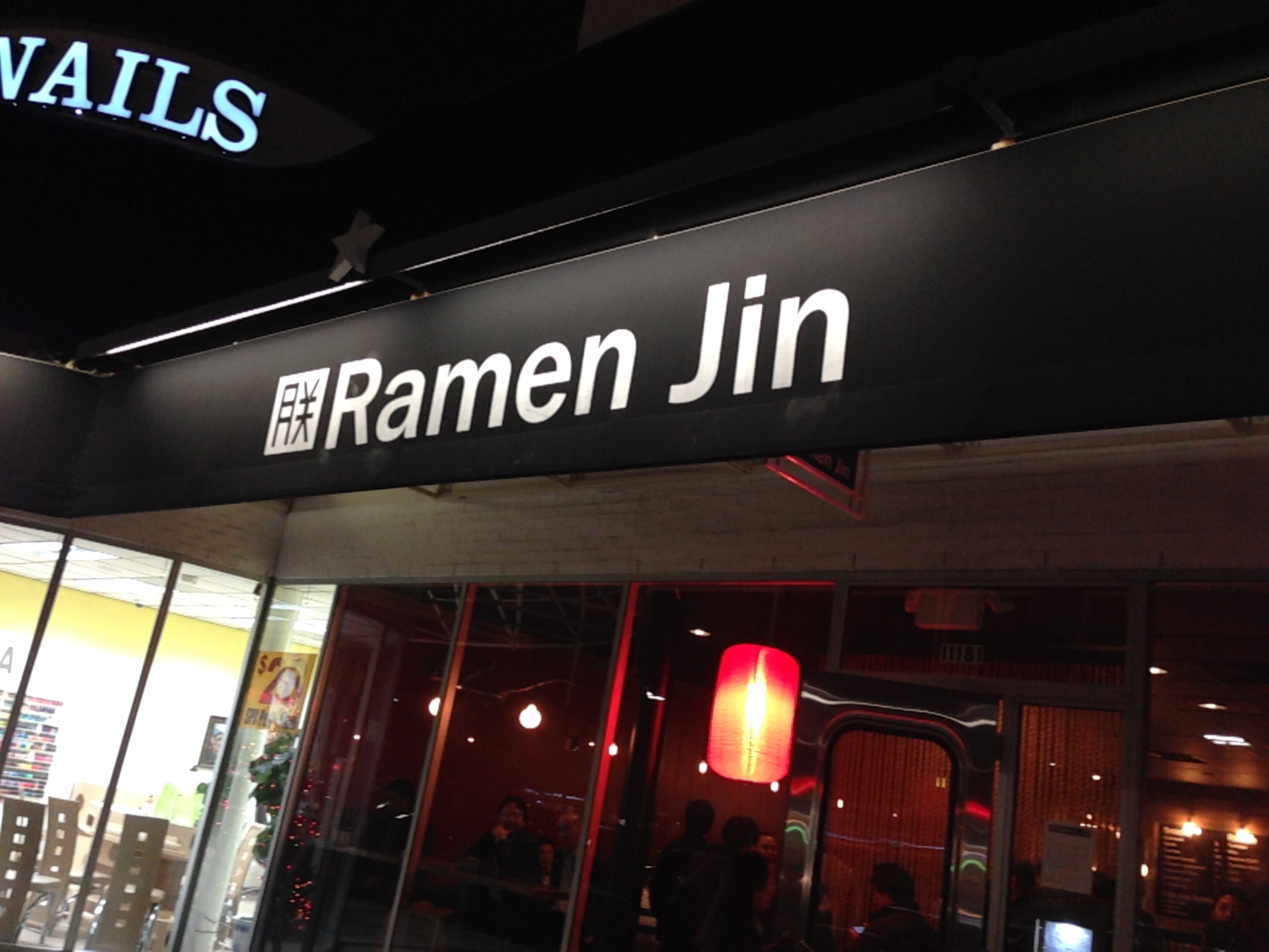 Ramen Jin storefront at night with a red lantern glowing inside