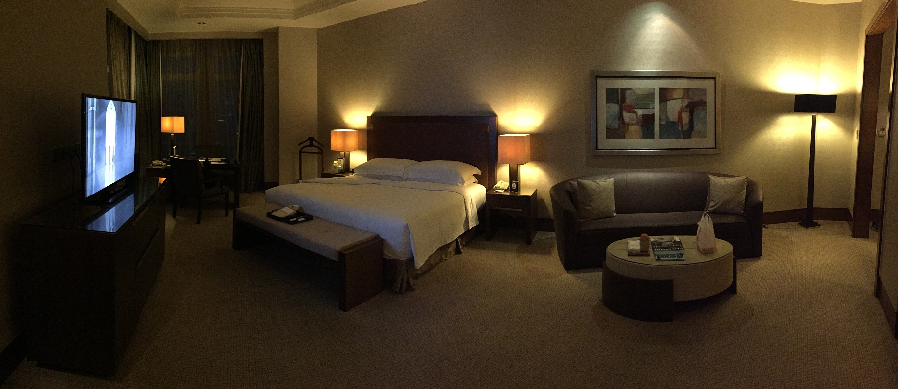 Corner suite at the Ritz-Carlton Jakarta, Pacific Place — king bed, sofa, warm lighting