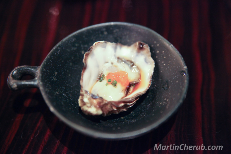 Oyster with ponzu in a handled ceramic dish
