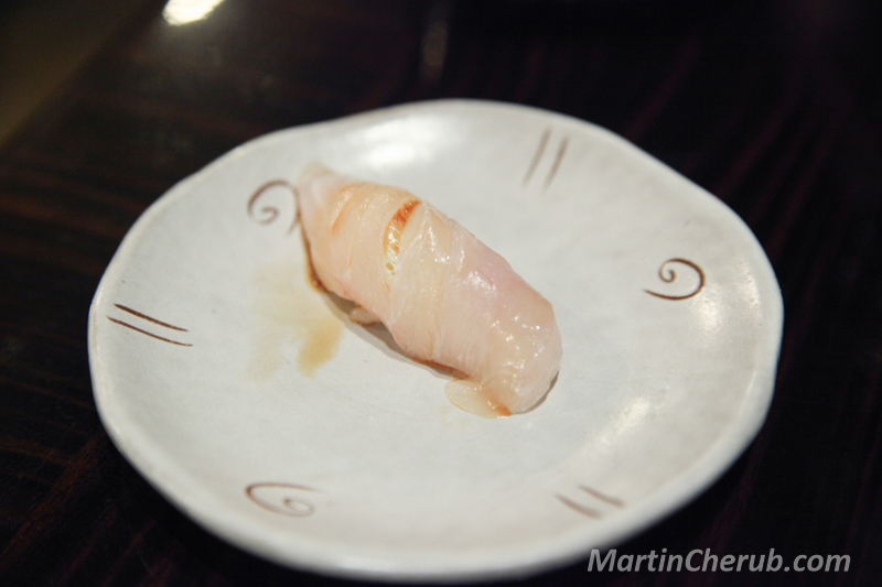 Nigiri on a white plate with swirl pattern